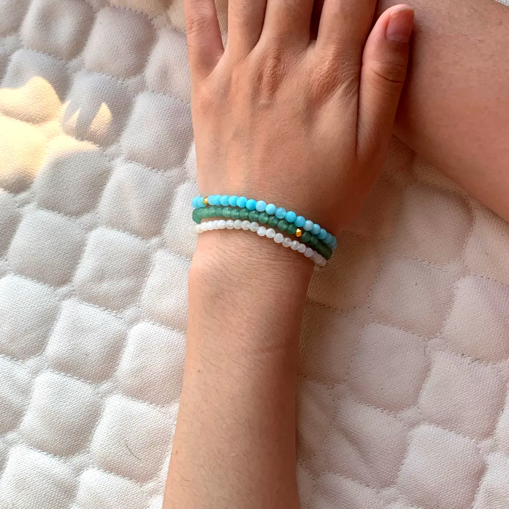Aquamarine bracelet layered with White Agate Bracelet and Green Aventurine Bracelet on the wrist — a stacked everyday styling